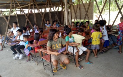 <p>MAKESHIFT CLASSROOM. Parents and children inside a makeshift classroom at Villa Sofia Elementary School in Tagpuro village, Tacloban City. Over 3,500 children will attend classes in temporary classrooms built within Yolanda housing projects starting next week. (<em>PNA Tacloban photo) </em></p>